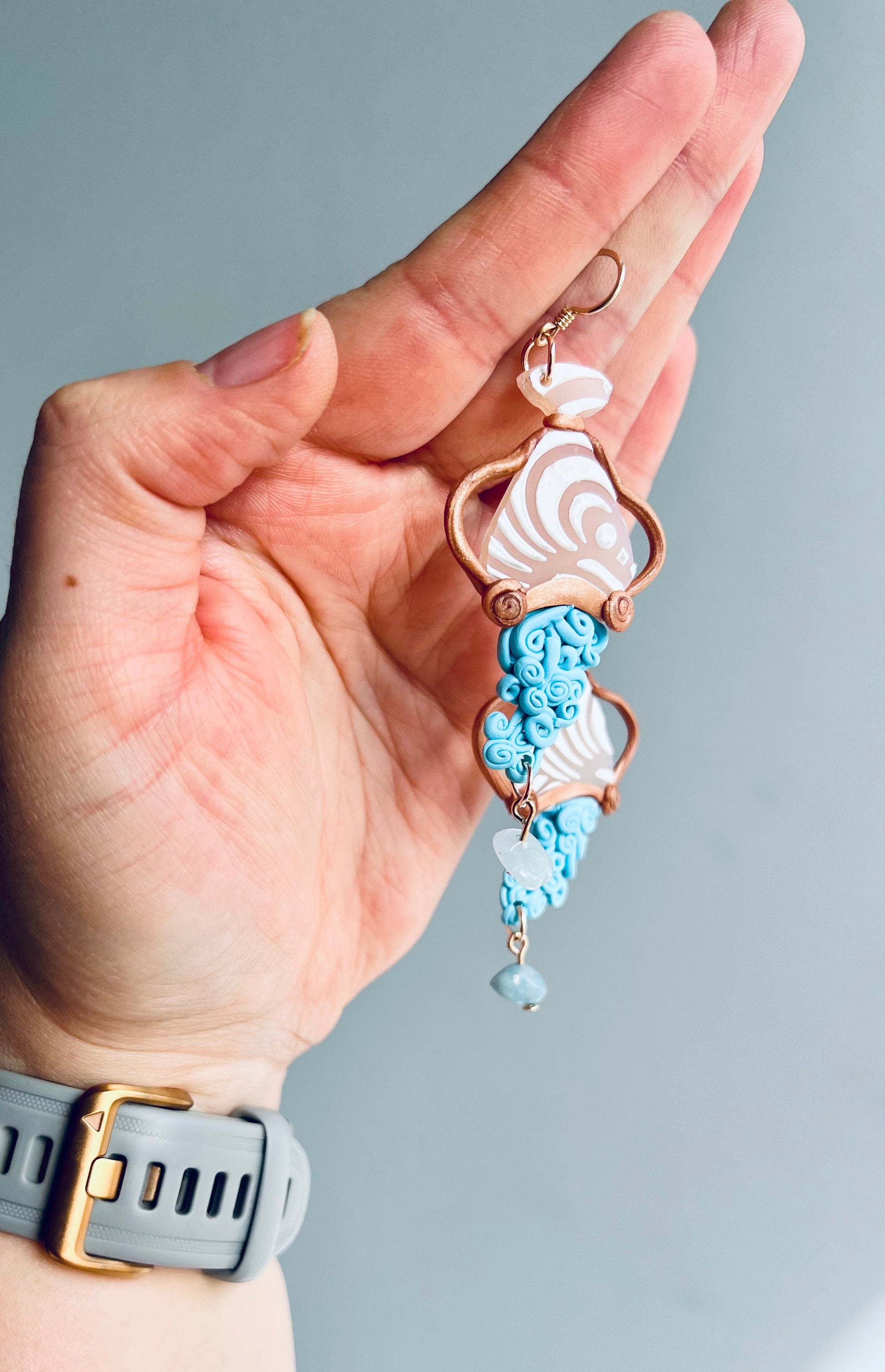 Artistic polymer clay Aquarius earrings depicting the Water Bearer symbol with a charming depiction of water spilling from a carafe. Handcrafted with care, these earrings capture the innovative and free-spirited essence of Aquarius. Shop now and embrace your Aquarian identity!