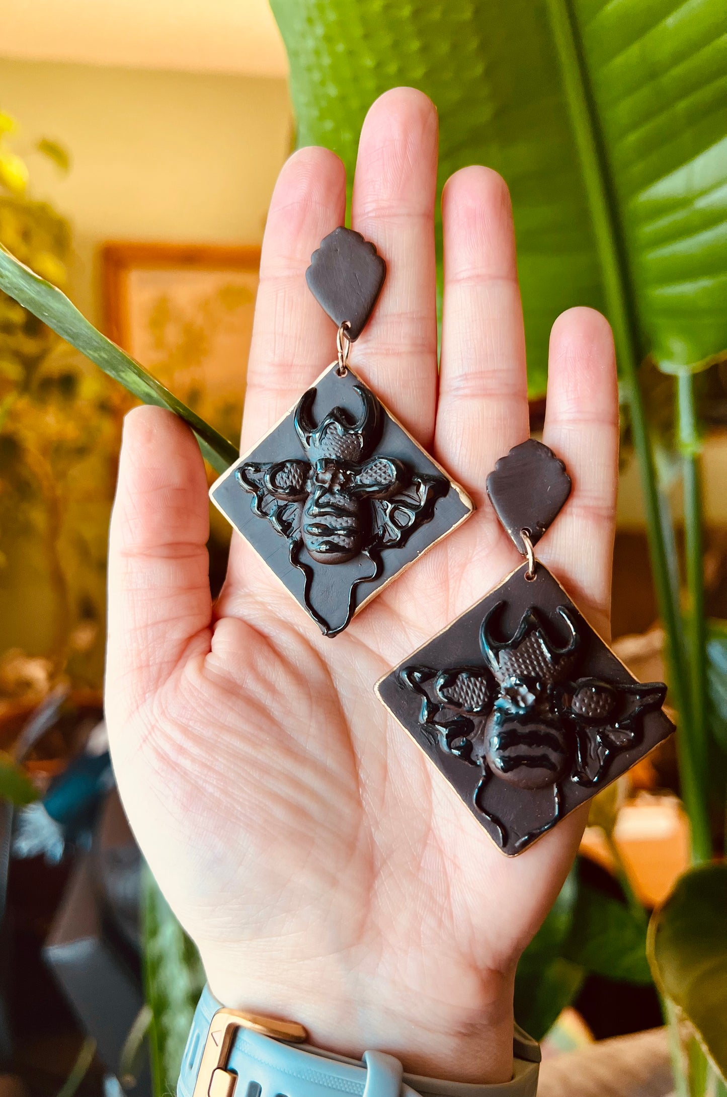 Tap into the strength and transformative properties of with our polymer clay stag beetle earrings, featuring a monochrome dark brown hue and elegant gold trim. Available now! They make the perfect unique gift for nature lovers, and gothic chic enthusiasts.