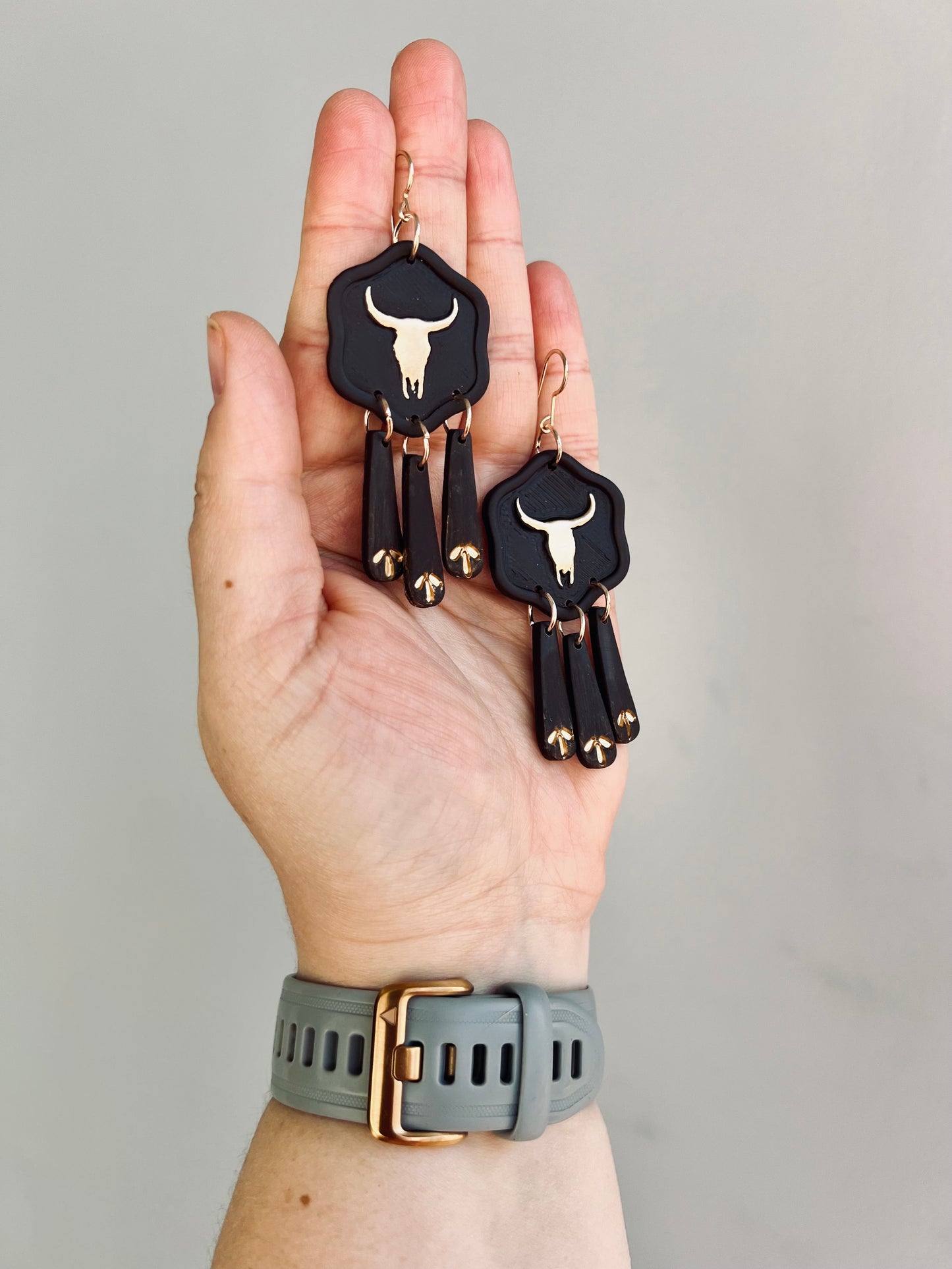 Ignite your western style with our stunning metallic gold longhorn skull earrings, complemented by deep brown details. These eye-catching accessories embody the spirit of the wild west, perfect for cowgirls with a bold sense of fashion.