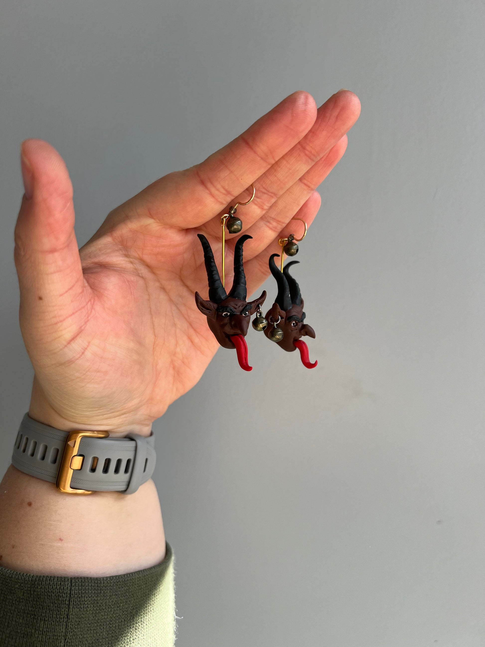 Channel the chilling whispers of folklore with our Krampus earrings, adorned with bells that echo through the night, perfect for those who embrace the macabre. His menacing red tongue flickers with an ominous hint, a chilling reminder of his sinister presence.