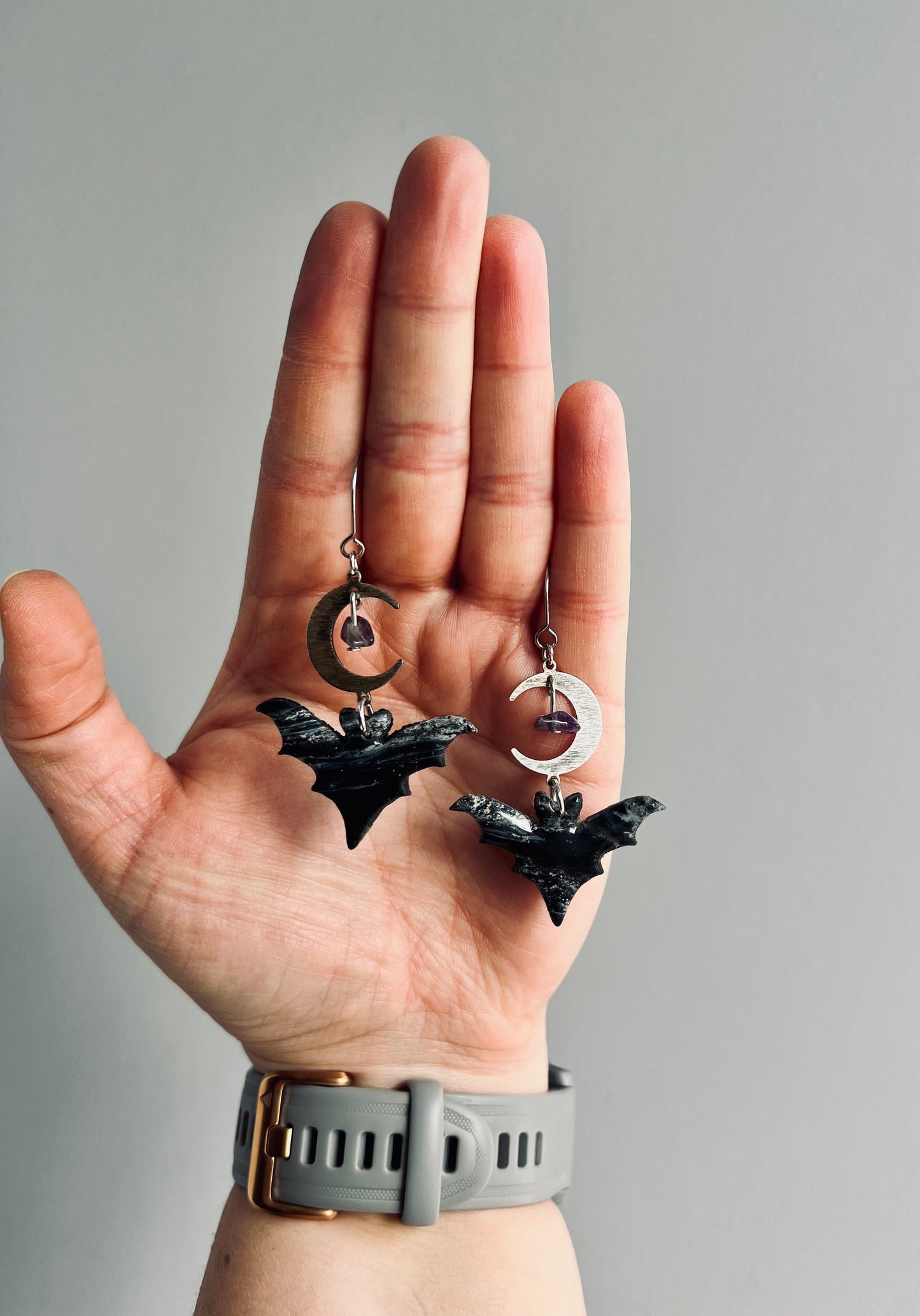 Elevate your style with our enchanting bat earrings, featuring a moon charm and amethyst stones, symbolizing intuition, transformation, and spiritual protection.