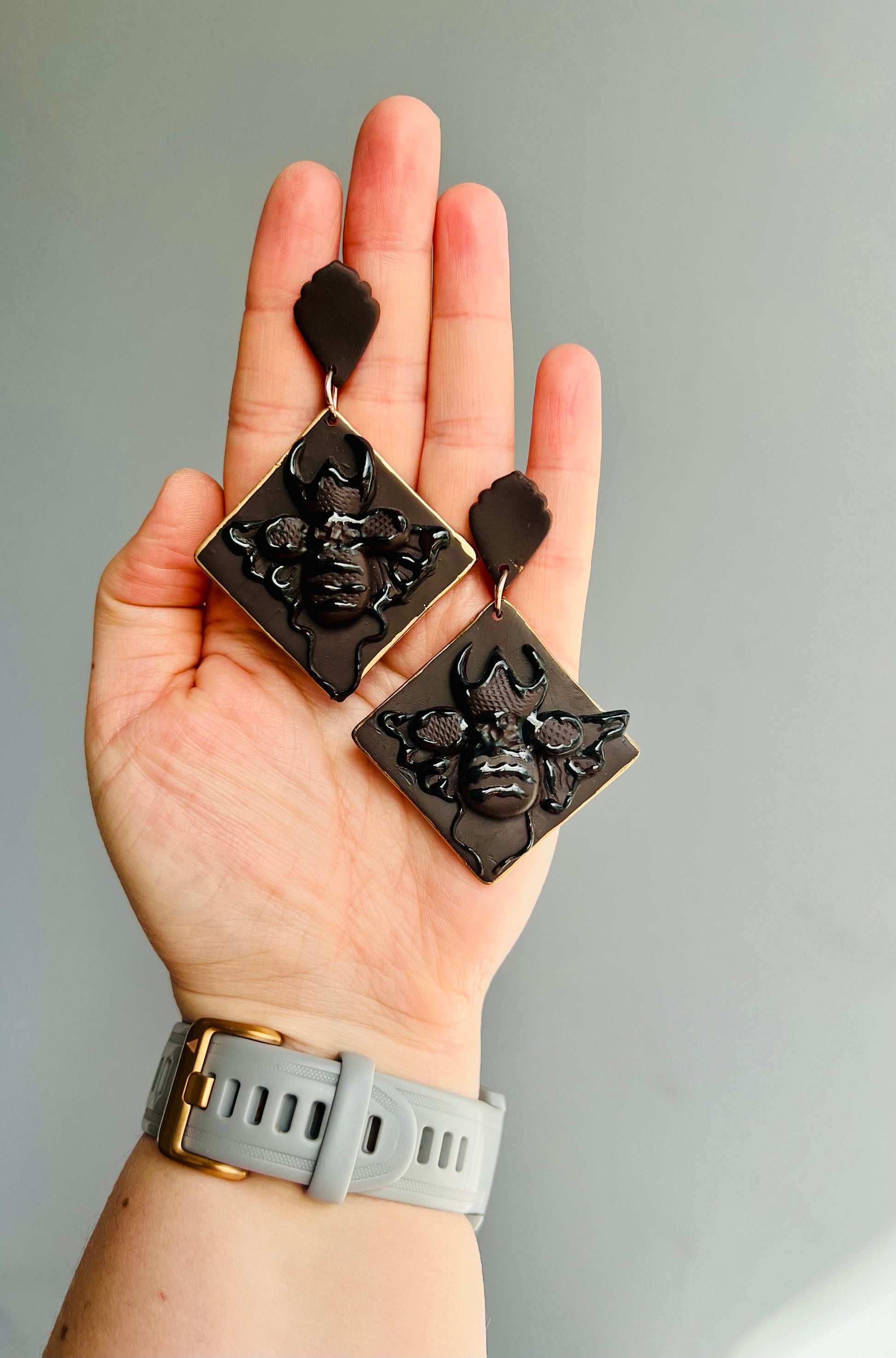 Complete your natural boho style with our monochrome stag beetle polymer clay earrings, adorned with a sleek gold trim, evoking the ancient wisdom and protective energies of this mystical creature.