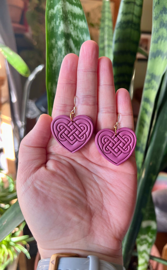 A pink Celtic Love Knot, symbolizing everlasting love and the eternal cycles of life in Celtic tradition. Believed to represent spiritual significance and exchanged as symbols of commitment, akin to modern-day rings.