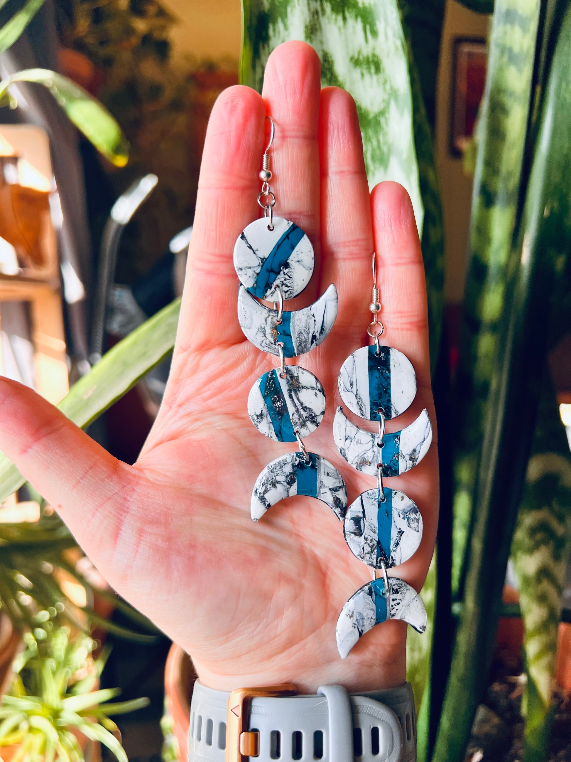 Capture the mystique of the Southwest with our moon phase-inspired polymer clay earrings, featuring faux marble and turquoise accents. Symbolizing the region's rugged beauty and connection to nature, these earrings evoke the enchanting allure of the desert moon. Elevate your style with a touch of southwestern charm and celestial elegance.