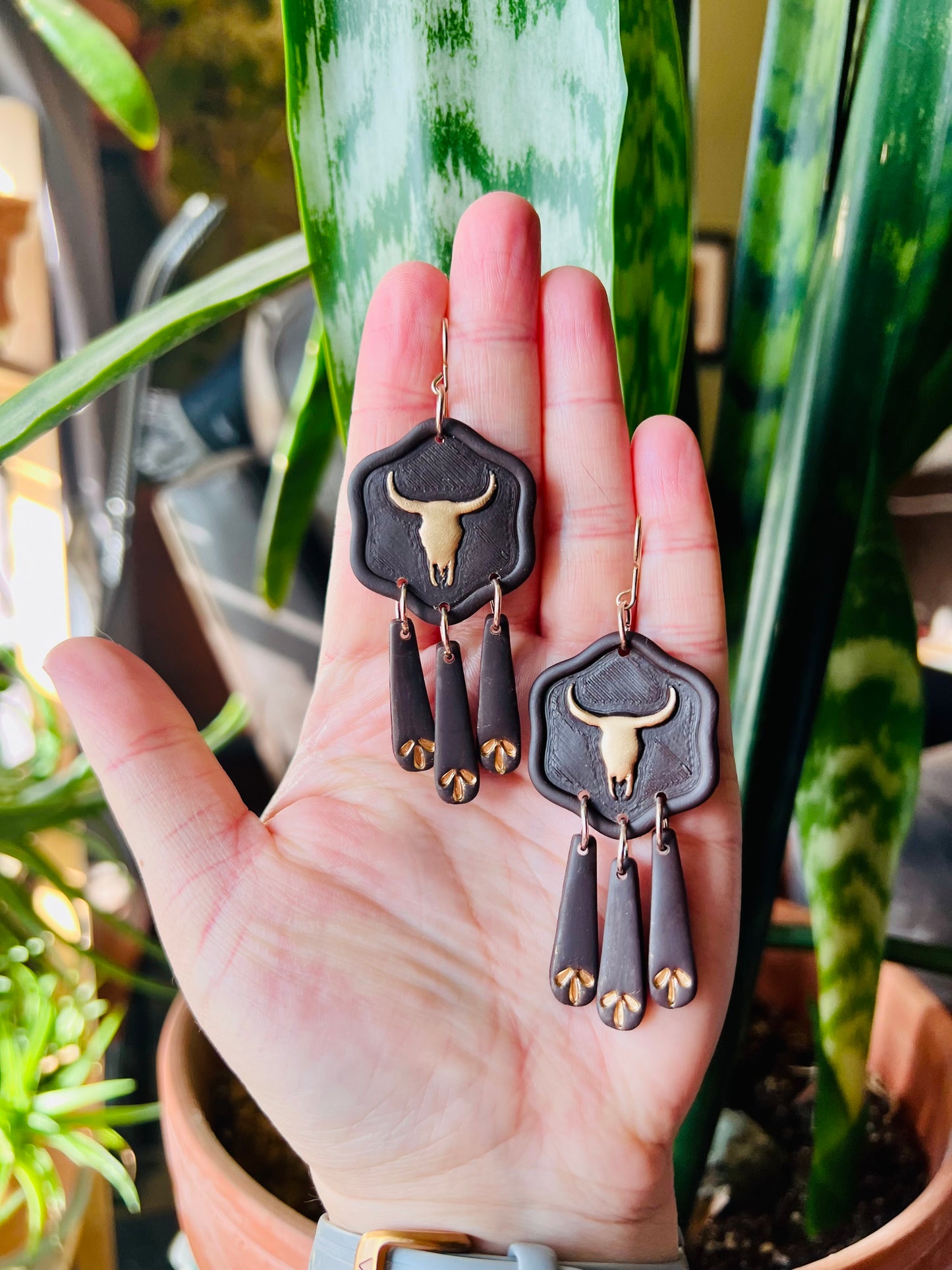 Complete your cowgirl ensemble with our metallic gold longhorn skull earrings, featuring deep brown accents for a touch of western flair. These statement earrings are perfect for adding rustic charm to any outfit.