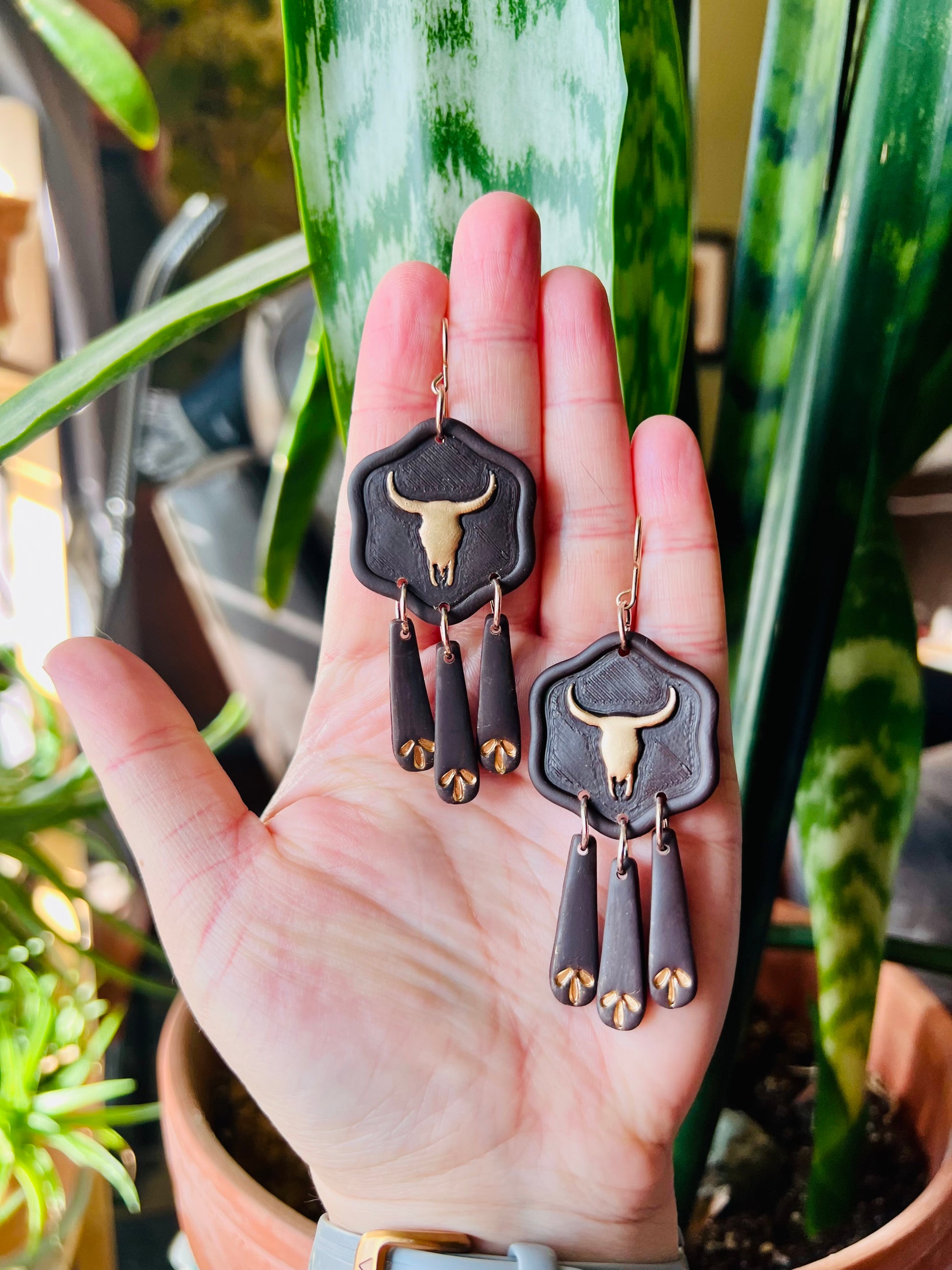 Complete your cowgirl ensemble with our metallic gold longhorn skull earrings, featuring deep brown accents for a touch of western flair. These statement earrings are perfect for adding rustic charm to any outfit.