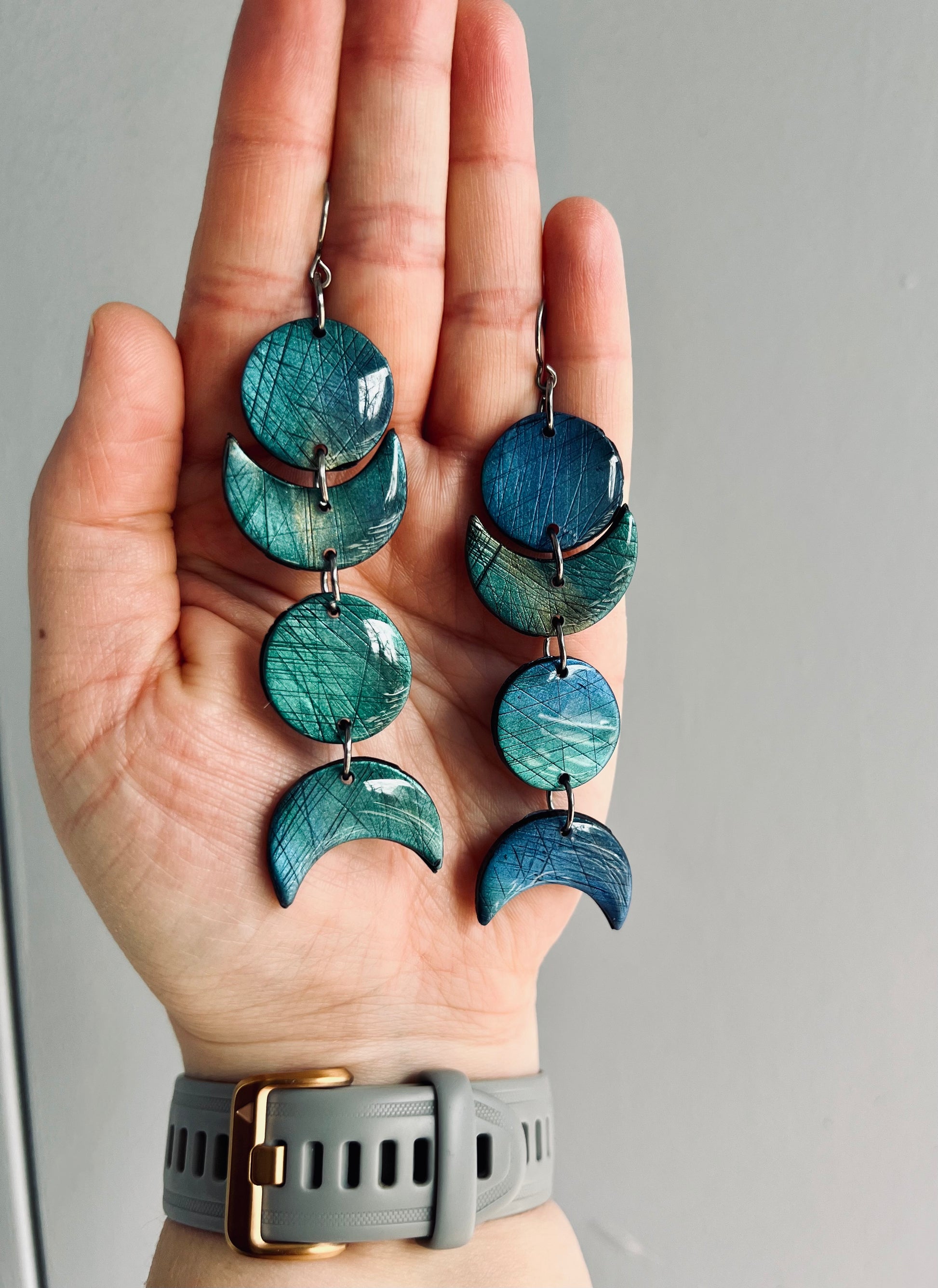Elegant moon phase polymer clay earrings adorned with mica pigments, echoing the enchanting hues of labradorite. Infused with the healing energies of labradorite, these earrings bring balance and protection to your daily wear.
