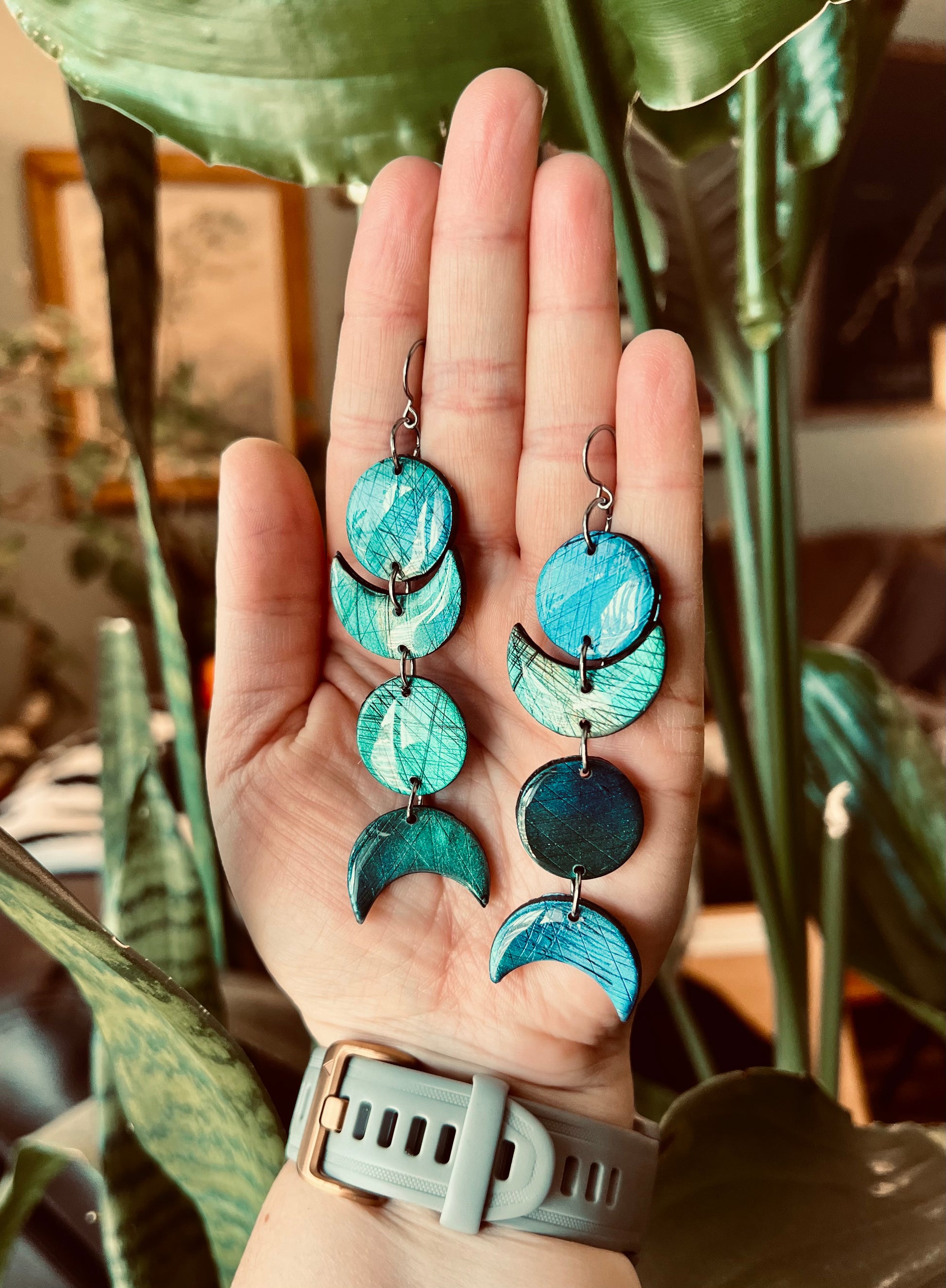 Experience the celestial allure of moon phase earrings crafted from polymer clay and mica pigments, evoking the mystical essence of labradorite. Enhance your spiritual journey with these stylish accessories.