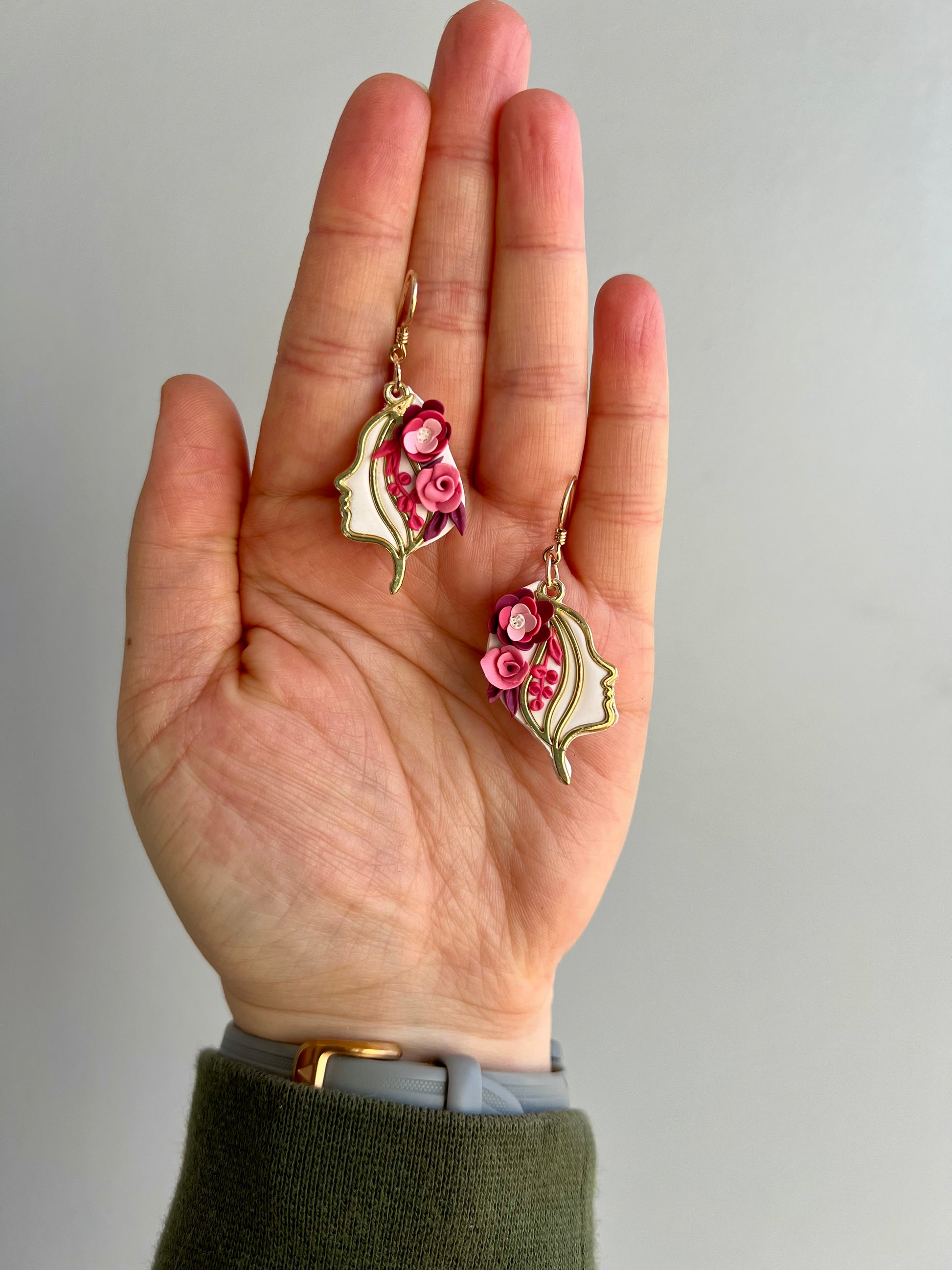 These earrings embody the wearer with the essence of the Norse goddess Freyja with these handmade earrings. Crafted from polymer clay, each delicate pink flower symbolizes love, fertility, and war, reflecting Freyja's diverse domains.