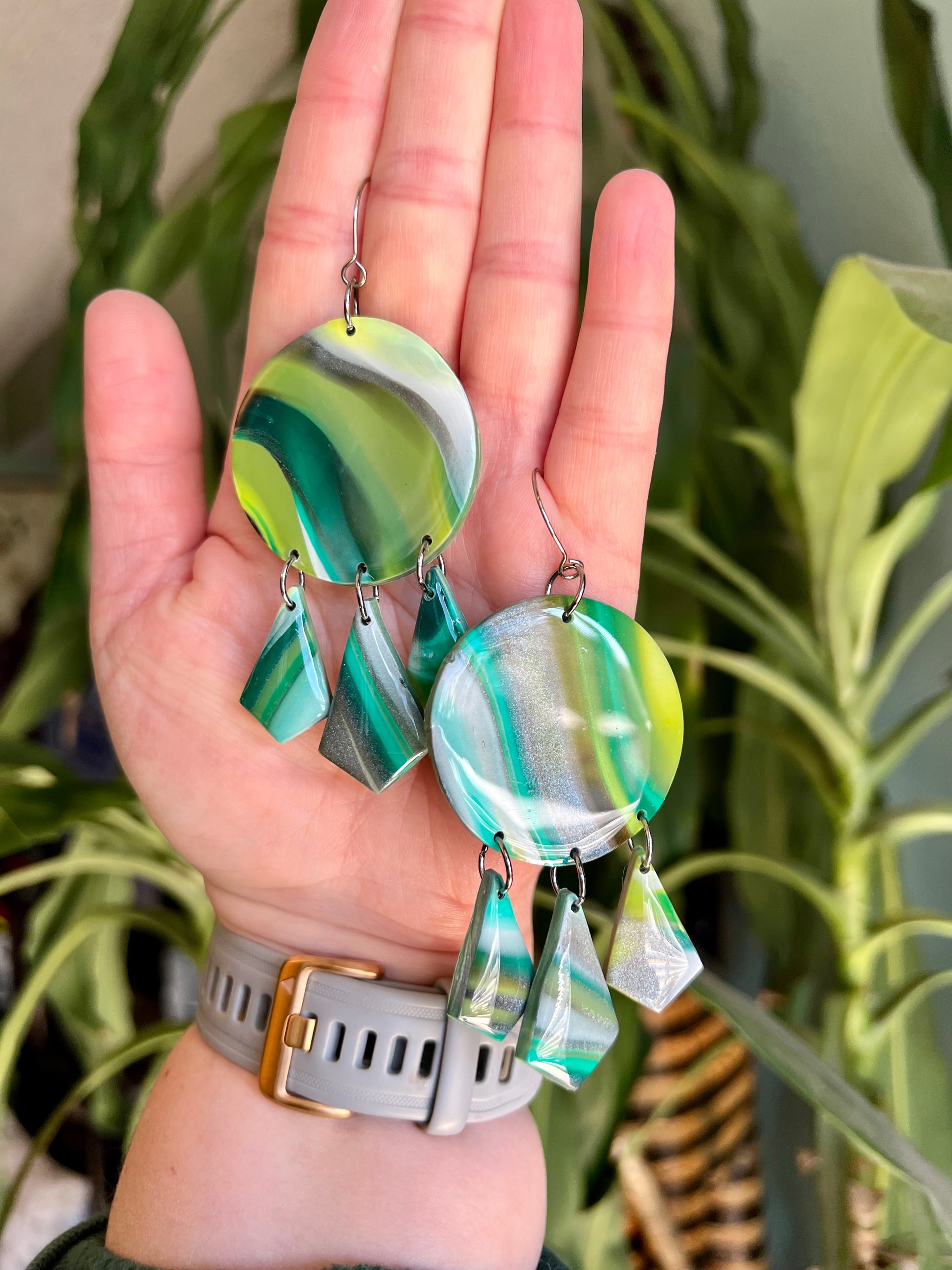 Celebrate the vitality of nature with our handmade polymer clay earrings, crafted in shades of green, silver, and white. Symbolizing renewal and immortality, each pair embodies the earth's energy, offering a one-of-a-kind expression of natural beauty.