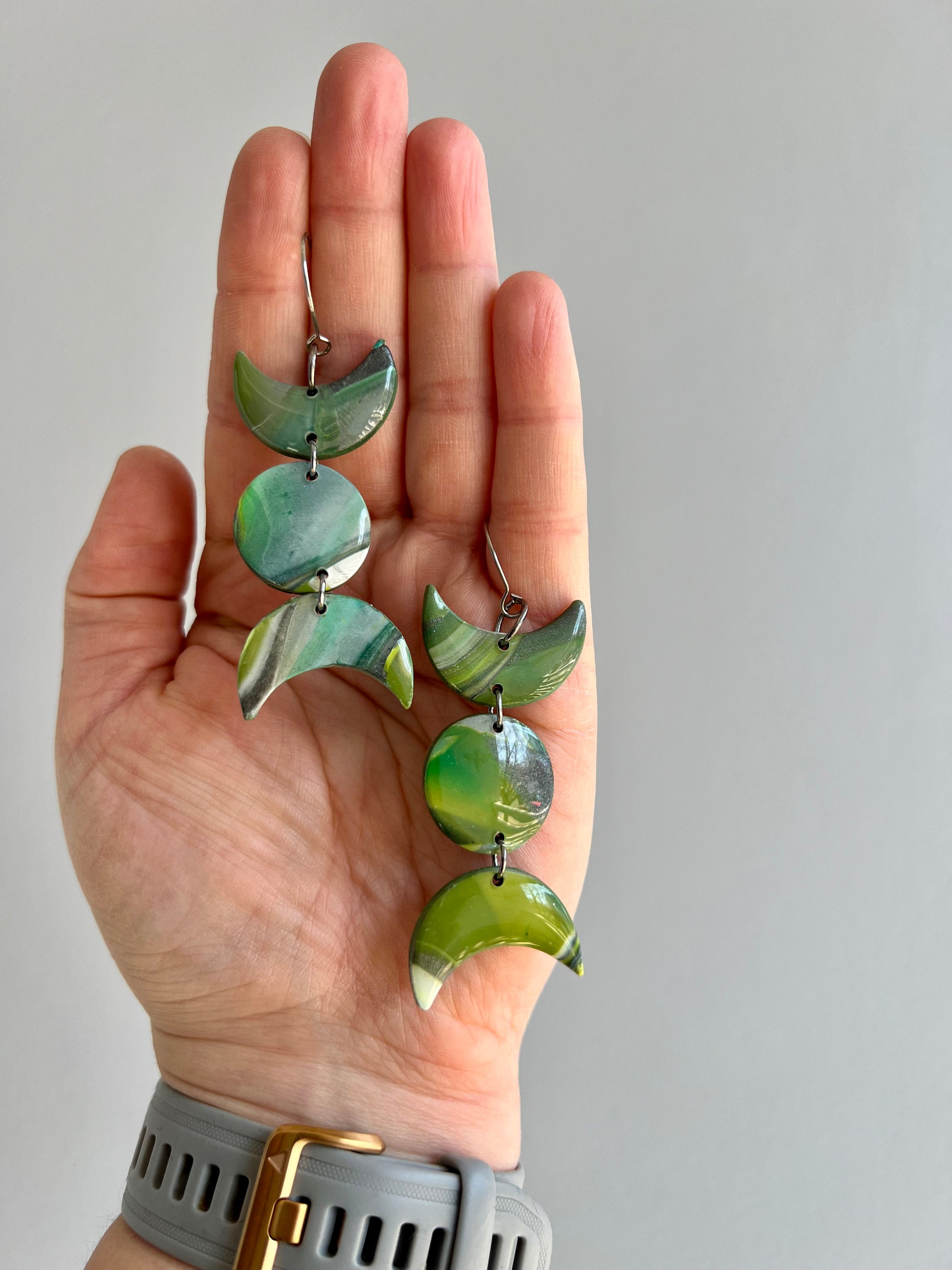 Discover the energy of the earth with our unique polymer clay earrings. Handmade from shades of green, silver, and white, each pair symbolizes rebirth and immortality, bringing a touch of nature's vitality to your style.