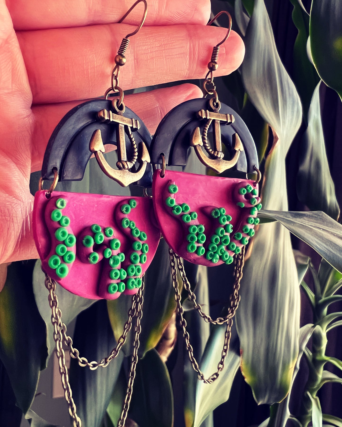 Unleash the magic of the sea with our fuchsia tentacle kraken earrings, complete with vibrant green suckers. These whimsical accessories add a touch of underwater fantasy to any look.