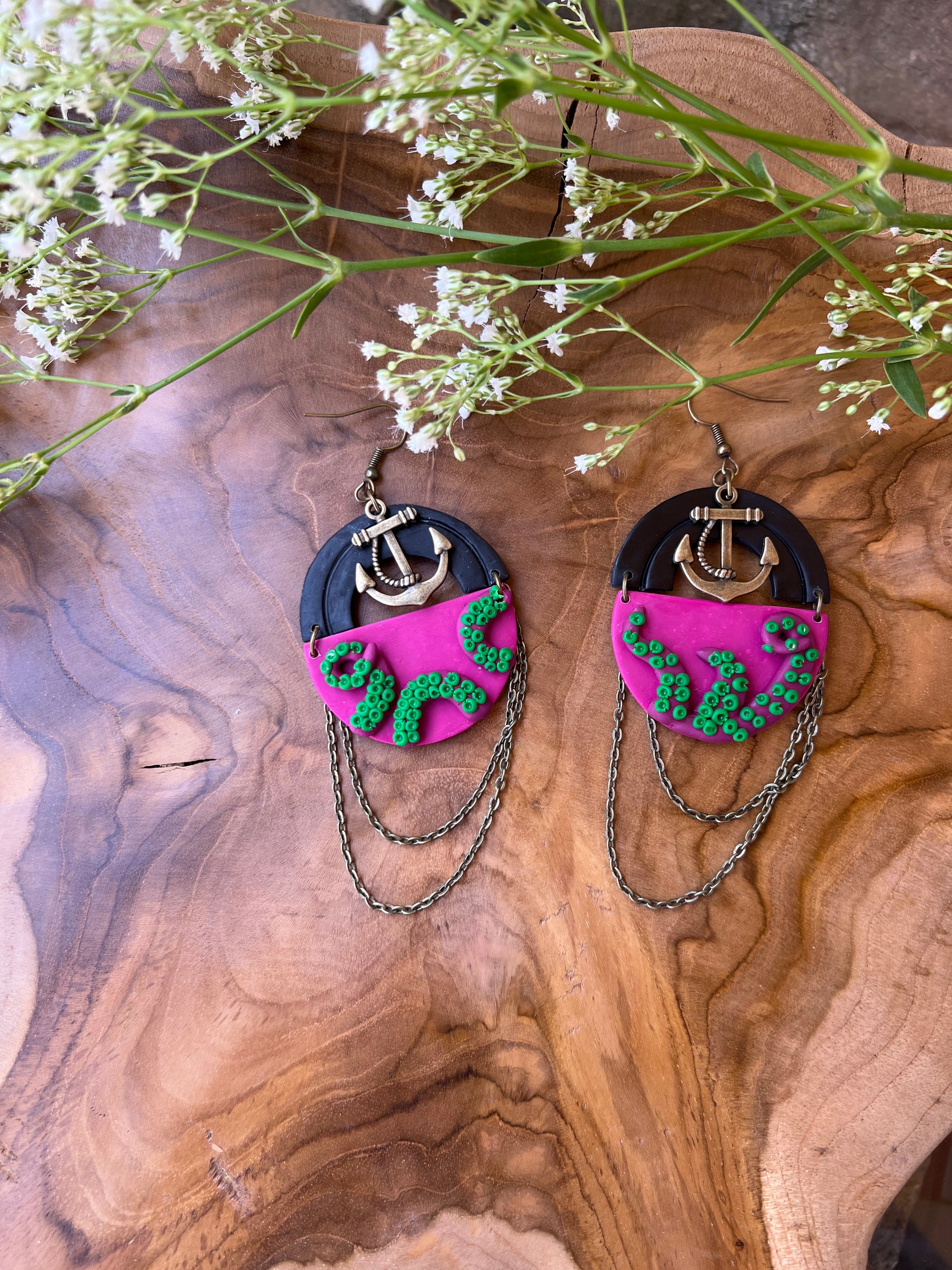 Inspire whimsy and mystery with these fuchsia tentacle kraken earrings, featuring intricate green suckers for an extra dose of oceanic charm. Perfect for lovers of mythical creatures and ocean-inspired fashion. Each pair is handcrafted out of polymer clay in Denver, Colorado.