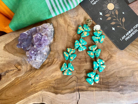 Stand out from the crowd this St. Patrick's Day with our emerald shamrock polymer clay earrings, adorned with luxurious gold leaf accents. Symbolizing luck and prosperity, these earrings add a touch of Irish charm to any ensemble.